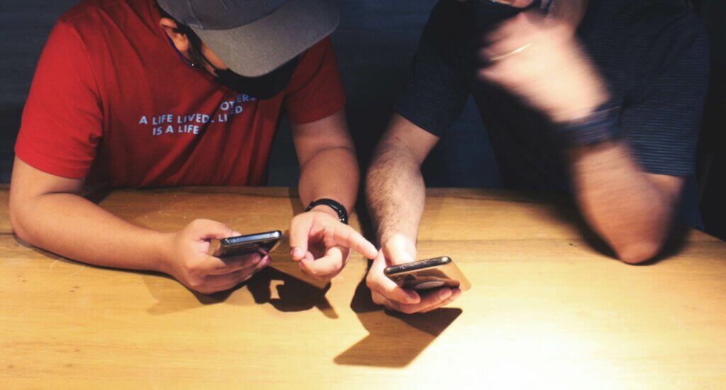 two agents at a table looking at phones