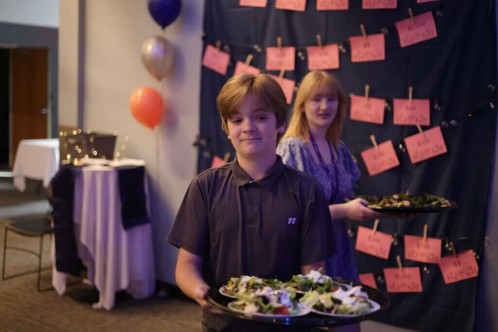 Students serving salads