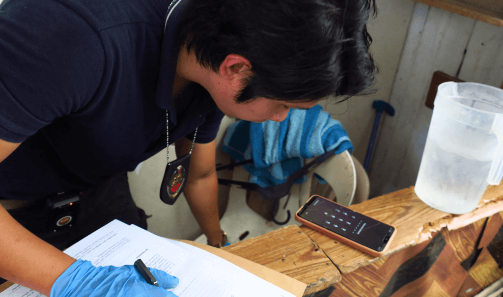 A National Bureau of Investigations (NBI) agent logs evidence after a raid in collaboration with Destiny Rescue in the Philippines