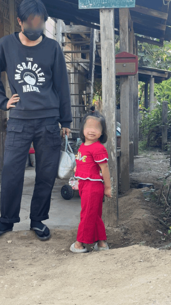 Aree smiles, standing next to a social worker